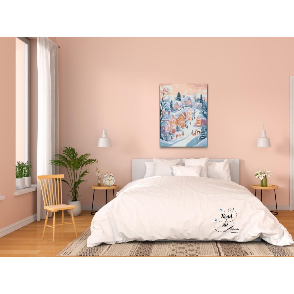 Diamond painting af en vinterlandsby med sne og varme lys i vinduerne, omgivet af grantræer og glade mennesker