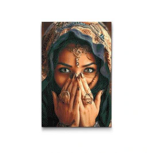 Diamond painting af kvinde med farverige ringe og tørklæde, der dækker munden – fokus på øjnene